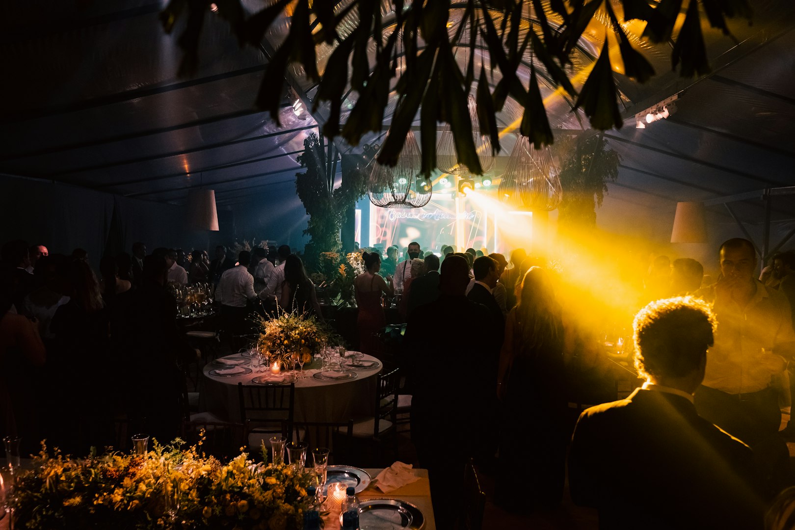 person discussing while standing in front of a large screen in front of people inside dim-lighted room
